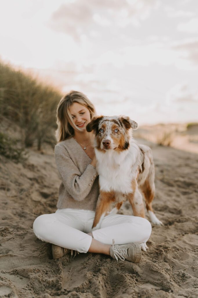 Frau mit Australian Shepherd im Sand von Zandvoort, eingefangen während eines Hunde-Fotoshootings in Holland