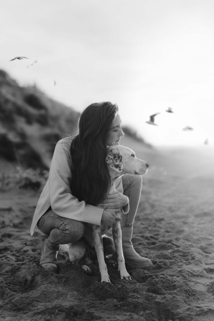Mensch und Hund zusammen am Strand bei Sonnenuntergang – natürliche Hundefotografie in den Niederlanden