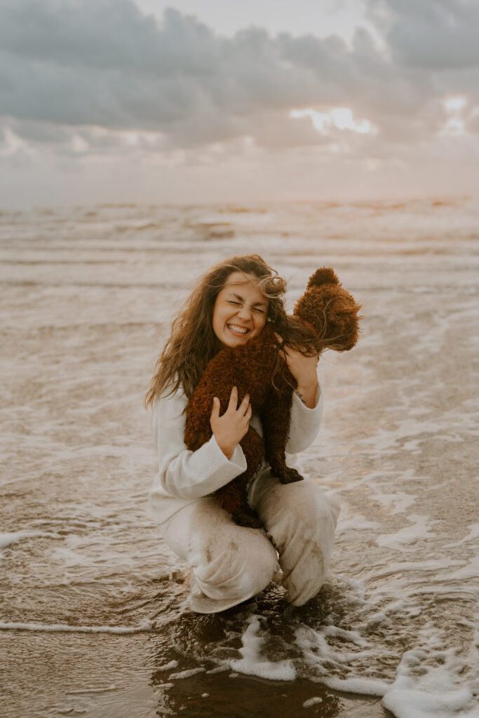 Lächelnde Frau mit Hund in den Dünen von Zandvoort, während des Fotoshootings