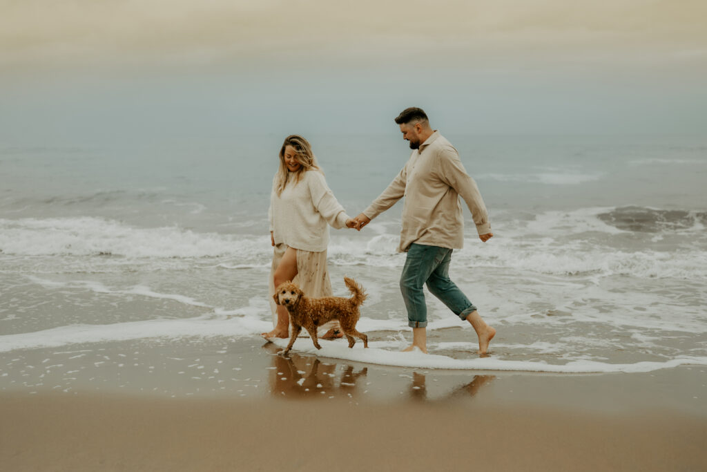 Hund mit Mann und Frau am Meer, gemeinsamer Moment in entspannter Atmosphäre